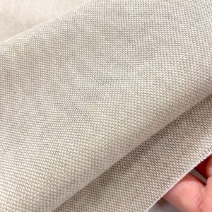Tessuto Panama in cotone color corda, tinto in filo per una maggiore stabilità del colore. La trama intrecciata e materica mostra sfumature naturali e profonde
