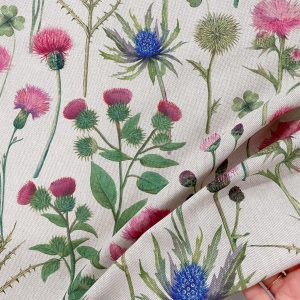 Tessuto in cotone Panama color corda con stampa botanica del fiore del cardo. Il disegno mostra i dettagli spinosi e i soffici capolini del cardo su base corda