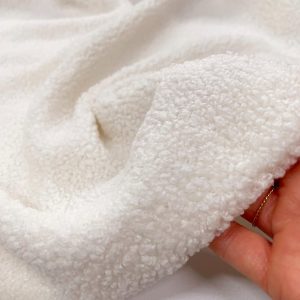 Tessuto teddy color avorio dalla trama morbida, ideale per rivestimenti d'arredo e confezione di capi o accessori per bambini certificato